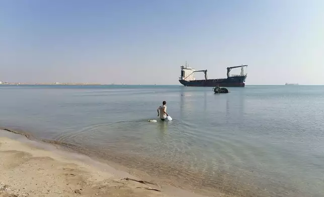 In this photo provided by the International Transport Workers’ Federation, Mohammad Aisha carries bags to the abandoned cargo ship MV Aman in Egyptian waters in March 2021. In 2021 reports surfaced that he was living alone on the ship, forced to swim to shore for food and water. Though he left the ship in 2021, the case is still working its way through the courts three years later. He has not yet been paid, the ITF said. (ITF via AP)