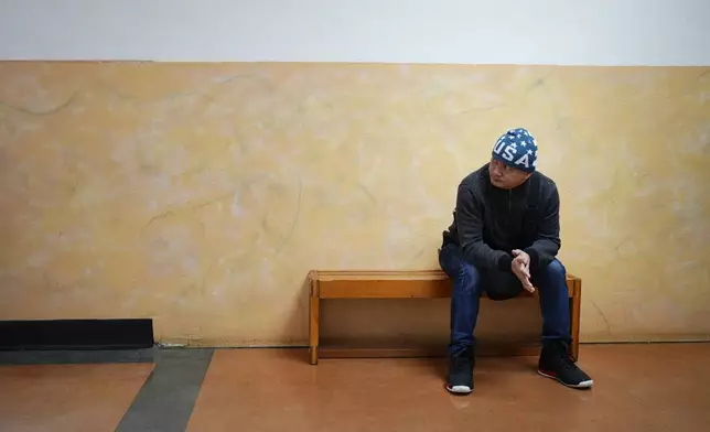 Seafarer Albert Docuyan waits on a bench at El Centro de la Raza, Monday, Feb. 5, 2024, in Seattle. While waiting for backpay, stuck in the U.S., Docuyan’s wife moved from the Philippines to Malaysia to find work that could pay the fees for their children’s school. (AP Photo/Lindsey Wasson)