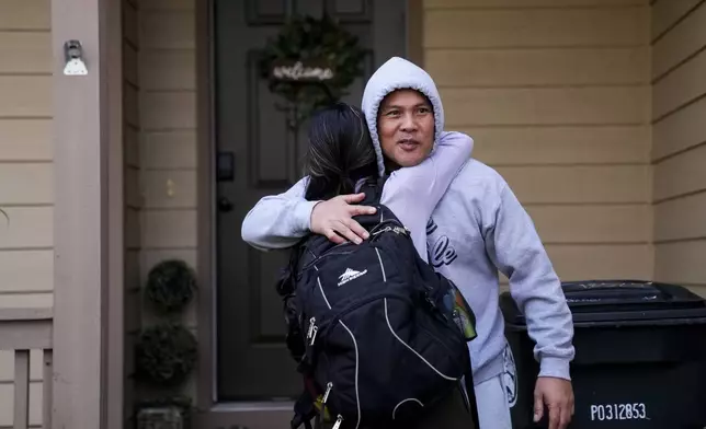 Seafarer Reyner Dagalea greets volunteer Mika Magbanua at a temporary rental house in Lacey, Wash., on Tuesday, Jan. 30, 2024. (AP Photo/Lindsey Wasson)