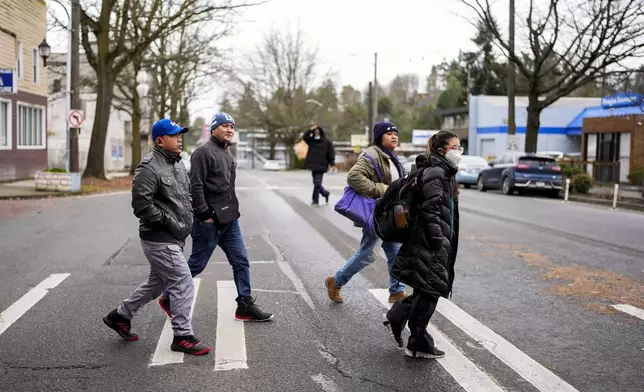 From left, seafarers Richard Zambales and Albert Docuyan walk to take a written driver's license test with community activists and volunteers Jill Mangaliman and Mika Magbanua Monday, Feb. 5, 2024, in Seattle. (AP Photo/Lindsey Wasson)