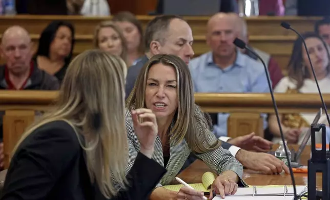 Karen Read chats with her attorney at her murder trial at Dedham Superior Court on Tuesday, May 7, 2024, in Dedham, Mass. Read is facing charges including second degree murder in the 2022 death of her boyfriend Boston Officer John O’Keefe. (Stuart Cahill/The Boston Herald via AP, Pool)