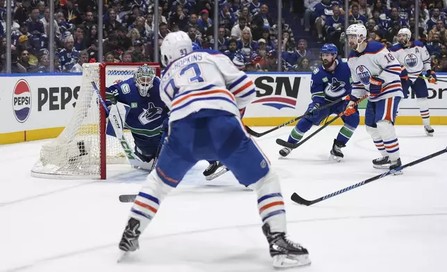 Edmonton Oilers' Ryan Nugent-Hopkins, front left, scores against Vancouver Canucks goalie Arturs Silovs (31) as Canucks' Filip Hronek (17) and Oilers' Zach Hyman (18) and Leon Draisaitl (29) watch during the second period in Game 7 of an NHL hockey Stanley Cup second-round playoff series in Vancouver, British Columbia, Monday, May 20, 2024. (Darryl Dyck/The Canadian Press via AP)