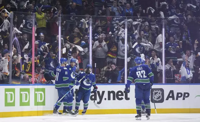 Vancouver Canucks' Nikita Zadorov, Dakota Joshua, Conor Garland and Ian Cole, from left, celebrate Joshua's goal against the Edmonton Oilers during the second period of Game 1 of a second-round NHL hockey Stanley Cup playoffs series, Wednesday, May 8, 2024, in Vancouver, British Columbia. (Darryl Dyck/The Canadian Press via AP)