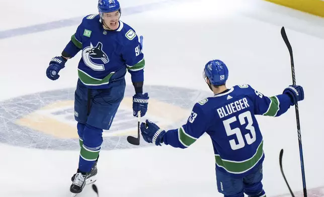 Vancouver Canucks' Nikita Zadorov celebrates his goal against the Edmonton Oilers with Teddy Blueger during the third period of Game 1 of a second-round NHL hockey Stanley Cup playoffs series, Wednesday, May 8, 2024, in Vancouver, British Columbia. (Ethan Cairns/The Canadian Press via AP)