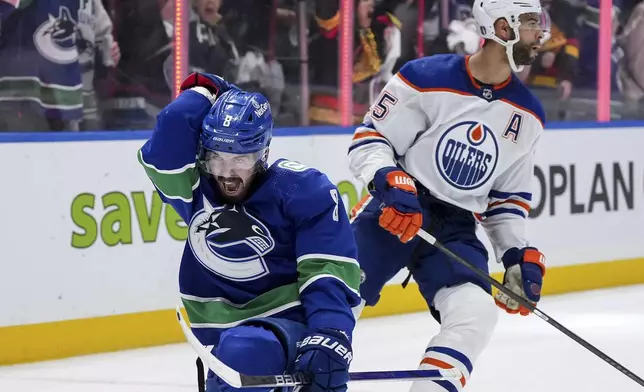 Vancouver Canucks' Conor Garland, left, celebrates his goal, next to Edmonton Oilers' Darnell Nurse during the third period of Game 1 of a second-round NHL hockey Stanley Cup playoffs series, Wednesday, May 8, 2024, in Vancouver, British Columbia. (Darryl Dyck/The Canadian Press via AP)