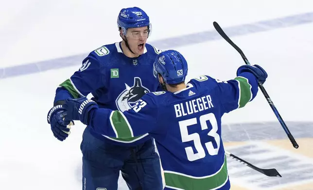 Vancouver Canucks' Nikita Zadorov celebrates his goal against the Edmonton Oilers with Teddy Blueger during the third period of Game 1 of a second-round NHL hockey Stanley Cup playoffs series, Wednesday, May 8, 2024, in Vancouver, British Columbia. (Ethan Cairns/The Canadian Press via AP)