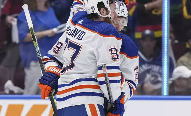 Edmonton Oilers' Connor McDavid, left, and Leon Draisaitl, right, celebrate after they defeated the Vancouver Canucks in Game 7 of an NHL hockey Stanley Cup second-round playoff series in Vancouver, British Columbia, Monday, May 20, 2024. (Darryl Dyck/The Canadian Press via AP)