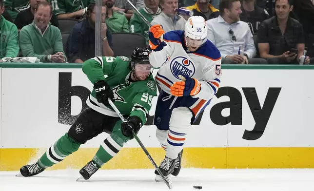 Dallas Stars center Matt Duchene (95) passes the puck next to Edmonton Oilers' Dylan Holloway (55) during the second period of Game 1 of the Western Conference finals in the NHL hockey Stanley Cup playoffs Thursday, May 23, 2024, in Dallas. (AP Photo/Tony Gutierrez)