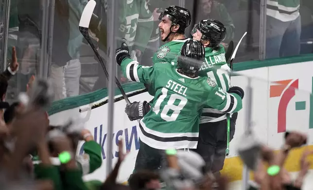 Dallas Stars' Sam Steel (18), Mason Marchment, left rear, and Ty Dellandrea (10) celebrate after Marchment scored against the Edmonton Oilers during the third period in Game 2 of the Western Conference finals in the NHL hockey Stanley Cup playoffs Saturday, May 25, 2024, in Dallas. (AP Photo/Tony Gutierrez)