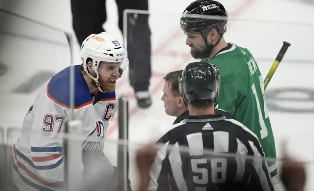 Dallas Stars left wing Jamie Benn, right, looks on as Edmonton Oilers center Connor McDavid (97) reacts after a ruling against him by the officials during overtime in Game 1 of the NHL hockey Western Conference Stanley Cup playoff finals, Thursday, May 23, 2024, in Dallas. (AP Photo/Tony Gutierrez)