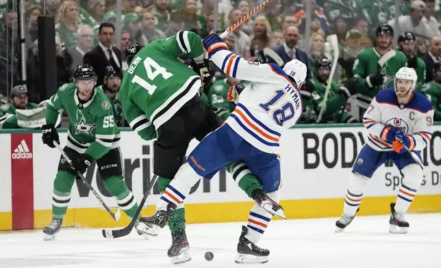 Dallas Stars' Jamie Benn (14) and Edmonton Oilers' Zach Hyman (18) collide while competing for the puck during the second period of Game 1 of the Western Conference finals in the NHL hockey Stanley Cup playoffs Thursday, May 23, 2024, in Dallas. (AP Photo/Tony Gutierrez)