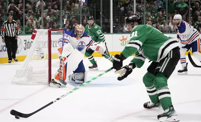 Edmonton Oilers goaltender Stuart Skinner (74) watches as Dallas Stars center Tyler Seguin (91) takes control of the puck during the first period in Game 2 of the Western Conference finals in the NHL hockey Stanley Cup playoffs Saturday, May 25, 2024, in Dallas. (AP Photo/Tony Gutierrez)