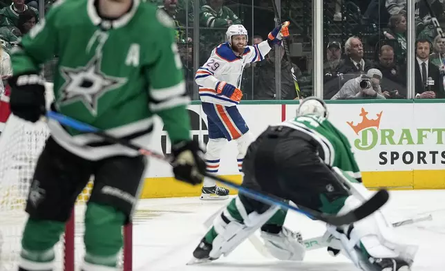 Edmonton Oilers center Leon Draisaitl, rear, celebrates after scoring against the Dallas Stars during the second period of Game 1 of the Western Conference finals in the NHL hockey Stanley Cup playoffs Thursday, May 23, 2024, in Dallas. (AP Photo/Tony Gutierrez)
