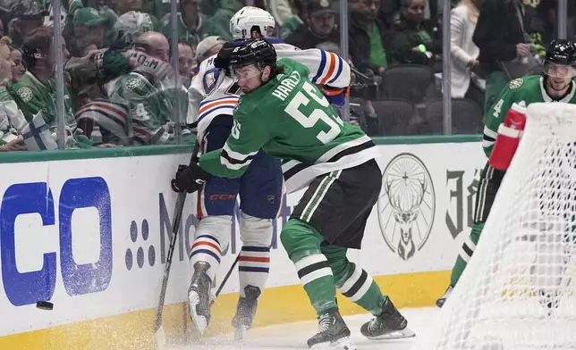 Dallas Stars defenseman Thomas Harley (55) slams Edmonton Oilers center Connor McDavid, left, against the boards as they compete for the puck during the second period in Game 2 of the Western Conference finals in the NHL hockey Stanley Cup playoffs Saturday, May 25, 2024, in Dallas. (AP Photo/Tony Gutierrez)