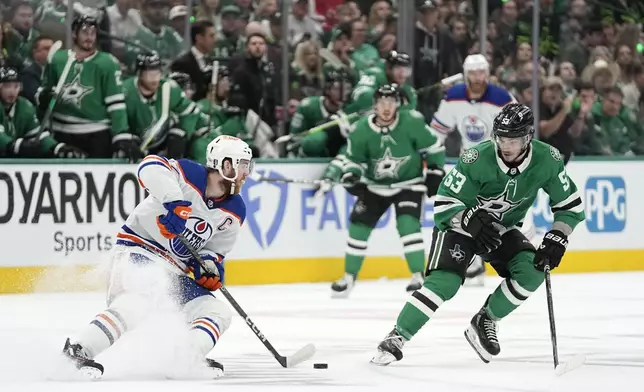 Edmonton Oilers center Connor McDavid (97) works to get the puck past Dallas Stars center Wyatt Johnston (53) during the first period of Game 1 of the Western Conference finals in the NHL hockey Stanley Cup playoffs Thursday, May 23, 2024, in Dallas. (AP Photo/Tony Gutierrez)