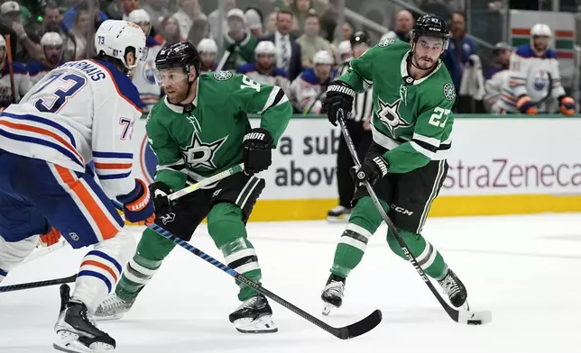 Dallas Stars left wing Mason Marchment (27) shoots as Edmonton Oilers' Vincent Desharnais (73) defends during the first period of Game 1 of the Western Conference finals in the NHL hockey Stanley Cup playoffs Thursday, May 23, 2024, in Dallas. (AP Photo/Tony Gutierrez)