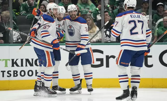 Edmonton Oilers' Connor McDavid (97), Leon Draisaitl (29), Evan Bouchard (2) and Brett Kulak (27) celebrate after Draisaitl scored against the Dallas Stars during the second period of Game 1 of the Western Conference finals in the NHL hockey Stanley Cup playoffs Thursday, May 23, 2024, in Dallas. (AP Photo/Tony Gutierrez)