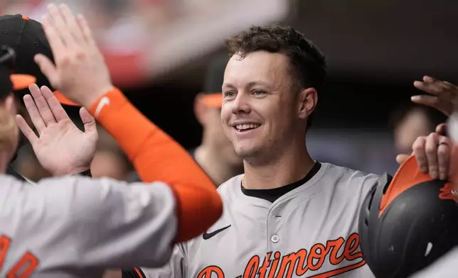 Baltimore Orioles' Ryan Mountcastle celebrates in the dugout after scoring on a single hit by teammate Anthony Santander in the first inning of a baseball game against the Cincinnati Reds, Sunday, May 5, 2024, in Cincinnati. (AP Photo/Carolyn Kaster)