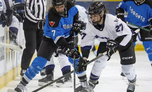Toronto's Olivia Knowles (7) and Minnesota's Taylor Heise (27) battle for the puck during the first period of a PWHL hockey game in Toronto on Wednesday, May 1, 2024. (Frank Gunn/The Canadian Press via AP)