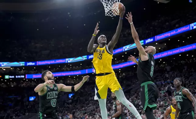 Indiana Pacers forward Pascal Siakam (43) drives to the basket between Boston Celtics forward Jayson Tatum (0) and guard Derrick White (9) during the first half of Game 2 of the NBA Eastern Conference basketball finals Thursday, May 23, 2024, in Boston. (AP Photo/Steven Senne)