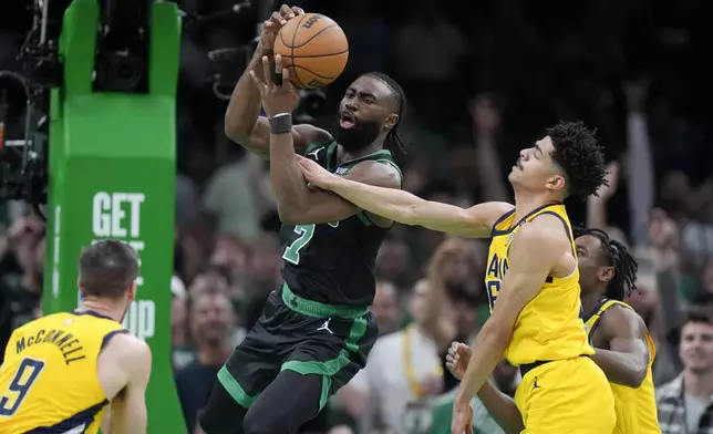 Boston Celtics guard Jaylen Brown (7) grabs a rebound next to Indiana Pacers guard Ben Sheppard, right, during the first half of Game 2 of the NBA Eastern Conference basketball finals Thursday, May 23, 2024, in Boston. (AP Photo/Steven Senne)