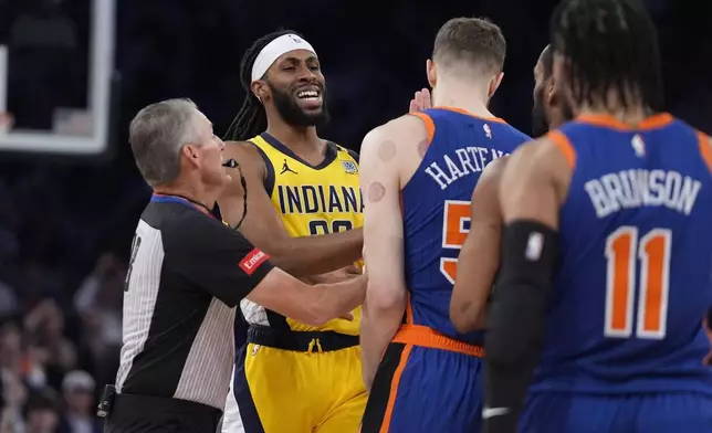 Referee Scott Foster, left, separates Indiana Pacers' Isaiah Jackson (22) and New York Knicks' Isaiah Hartenstein (55) during the first half of Game 5 in an NBA basketball second-round playoff series, Tuesday, May 14, 2024, in New York. (AP Photo/Frank Franklin II)