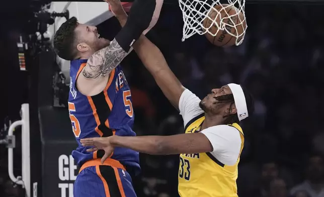 New York Knicks' Isaiah Hartenstein, left, dunks the ball in front of Indiana Pacers' Myles Turner during the first half of Game 5 in an NBA basketball second-round playoff series, Tuesday, May 14, 2024, in New York. (AP Photo/Frank Franklin II)