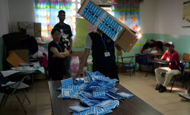 An electoral worker empties a ballot box to count after general elections polls closed in Panama City, Sunday, May 5, 2024. (AP Photo/Matias Delacroix)