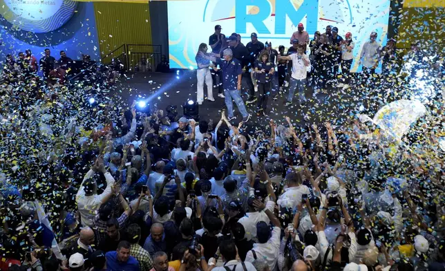 Presidential candidate Jose Raul Mulino, of the Achieving Goals party, center, waves to supporters after winning on the day of the general electing in Panama City, Sunday, May 5, 2024. (AP Photo/Matias Delacroix)