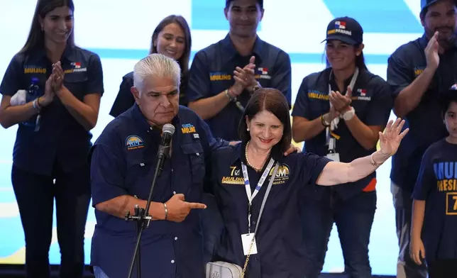 Presidential candidate Jose Raul Mulino, left, stands beside Marta Linares de Martinelli, the wife of former Panamanian President Ricardo Martinelli, as he addresses supporters after winning on the day of the general electing in Panama City, Sunday, May 5, 2024. (AP Photo/Matias Delacroix)