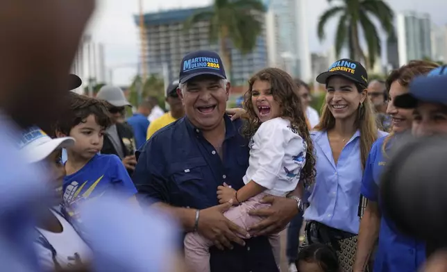 FILE - Presidential candidate Jose Raul Mulino holds his granddaughter Sofia accompanied by his daughter Monique, Sofia's mother, during a campaign event, in Panama City, April 26, 2024. Mulino replaced former president Ricardo Martinelli as the candidate for the Achieving Goals party. Martinelli was barred from running in March, because the ex-president was sentenced to more than 10 years in prison for money laundering. (AP Photo/Matias Delacroix, File)