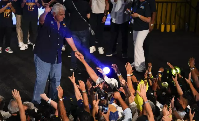 Presidential candidate Jose Raul Mulino, of the Achieving Goals party, hold hands with a supporter after winning on the day of the general electing in Panama City, Sunday, May 5, 2024. (AP Photo/Matias Delacroix)