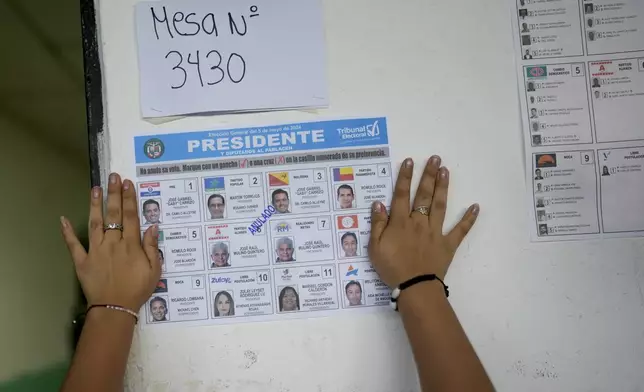 An electoral worker sticks a ballot on a polling station's wall to use as sample during a general election in Panama City, Sunday, May 5, 2024. (AP Photo/Matias Delacroix)