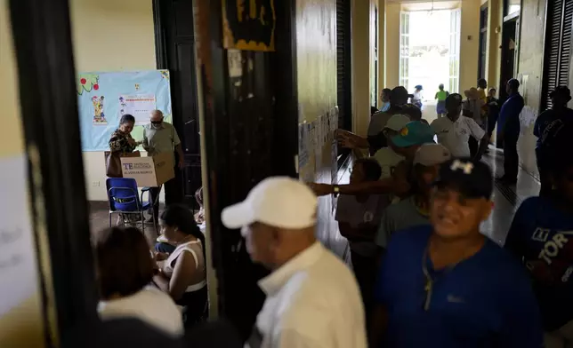 A man votes assisted by a woman during a general election in Panama City, Sunday, May 5, 2024. (AP Photo/Matias Delacroix)