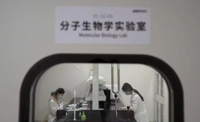 FILE - Workers in a Molecular Biology Lab in the SinoVac vaccine factory in Beijing on Thursday, Sept. 24, 2020. (AP Photo/Ng Han Guan, File)