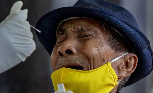 FILE - A man reacts as a nasal swab sample is collected from him to test for a COVID in Bangkok, Thailand, Wednesday, May 6, 2020. (AP Photo/Gemunu Amarasinghe, File)
