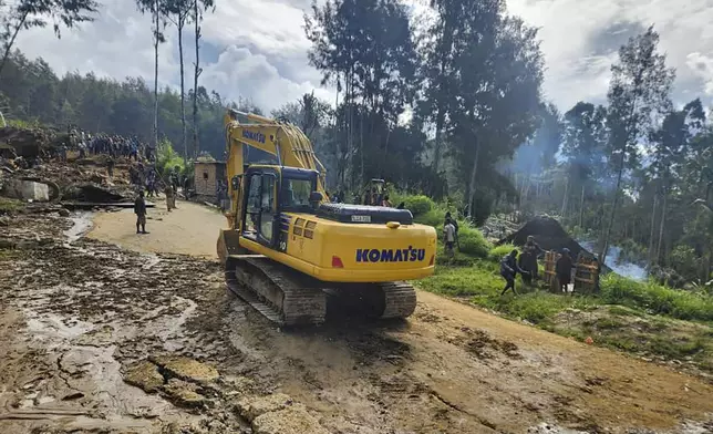 Villagers use heavy machinery to search through a landslide in Yambali in the Highlands of Papua New Guinea, Sunday, May 26, 2024. The International Organization for Migration feared Sunday the death toll from a massive landslide is much worse than what authorities initially estimated. (Mohamud Omer/International Organization for Migration via AP)