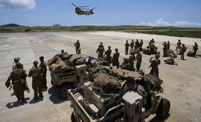 U.S. and Philippine troopers prepare to board a U.S. Army CH-47 helicopter at the airport at the Philippines' northernmost town of Itbayat, Batanes province during a joint military exercise on Monday, May 6, 2024. American and Filipino marines held annual combat-readiness exercises called Balikatan, Tagalog for shoulder-to-shoulder, in a show of allied battle readiness in the Philippines' northernmost island town of Itbayat along the strategic Bashi Channel off southern Taiwan. (AP Photo/Aaron Favila)