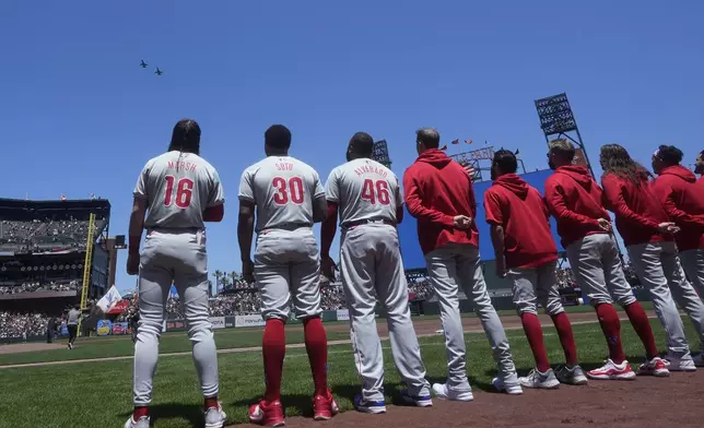 Planes fly over Oracle Park in honor of Memorial Day as Philadelphia Phillies players stand during the national anthem before a baseball game against the San Francisco Giants in San Francisco, Monday, May 27, 2024. (AP Photo/Jeff Chiu)