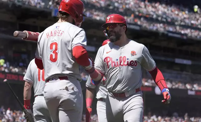 Philadelphia Phillies' Kyle Schwarber, right, is congratulated by Bryce Harper (3) after hitting a two-run home run that also scored Johan Rojas during the third inning of a baseball game against the San Francisco Giants in San Francisco, Monday, May 27, 2024. (AP Photo/Jeff Chiu)