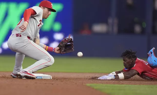 Philadelphia Phillies second base Bryson Stott, left, prepares to tag out Miami Marlins' Jazz Chisholm Jr. after Chisholm attempted to steal second base during the first inning of a baseball game, Saturday, May 11, 2024, in Miami. (AP Photo/Wilfredo Lee)