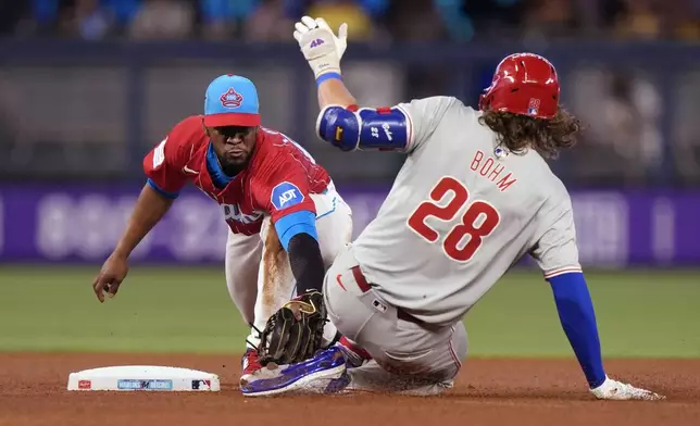 Miami Marlins second base Otto Lopez, left, tags out Philadelphia Phillies' Alec Bohm (28) after Bohm attempted to stretch out a base hit during the fourth inning of a baseball game, Saturday, May 11, 2024, in Miami. (AP Photo/Wilfredo Lee)