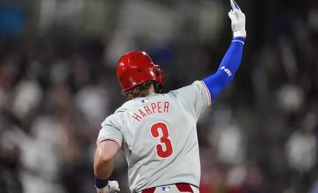 Philadelphia Phillies' Bryce Harper gestures as he runs the bases on a three-run home run off Colorado Rockies relief pitcher John Curtiss during the ninth inning of a baseball game Saturday, May 25, 2024, in Denver. (AP Photo/David Zalubowski)