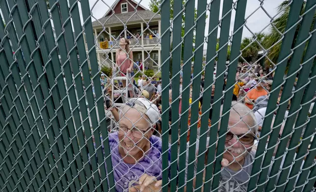 Fans unable to make it into the Fair Grounds listen to the Rolling Stones from behind a fence during the New Orleans Jazz and Heritage Festival in New Orleans, Thursday, May 2, 2024. (AP Photo/Matthew Hinton)