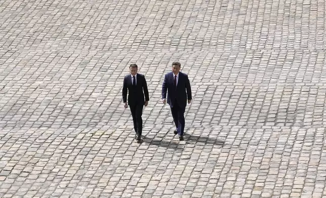 China's President Xi Jinping, right, and French President Emmanuel Macron walk during an official welcoming ceremony at the Hotel des Invalides monument, Monday, May 6, 2024 in Paris. (AP Photo/Christophe Ena)