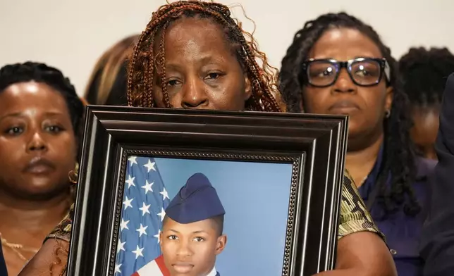 Chantimekki Fortson, mother of Roger Fortson, a U.S. Navy airman, holds a photo of her son during a news conference regarding his death, along with family and Attorney Ben Crump, Thursday, May 9, 2024, in Ft. Walton Beach, Fla. Fortson was shot and killed by police in his apartment on May 3, 2024. (AP Photo/Gerald Herbert)