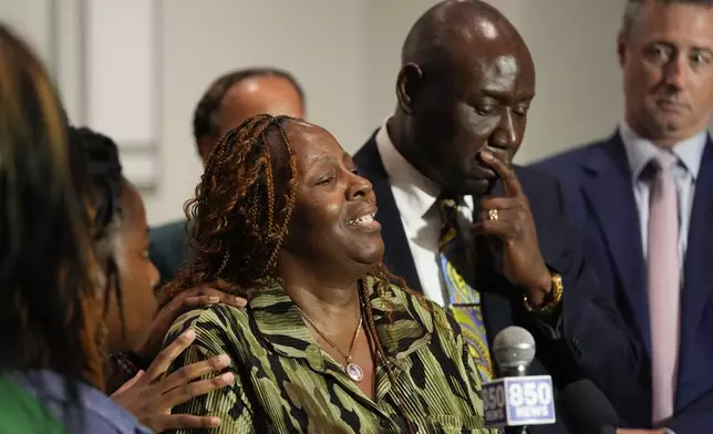 Chantimekki Fortson, mother of Roger Fortson, a U.S. Navy airman, speaks about her son during a news conference regarding his death, with Attorney Ben Crump, right, and attorney Brian Barr, far right. Thursday, May 9, 2024, in Ft. Walton Beach, Fla. Fortson was shot and killed by police in his apartment on May 3, 2024. (AP Photo/Gerald Herbert)