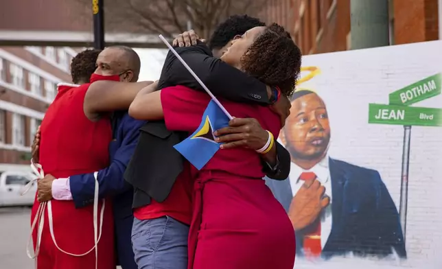 FILE - The family of Botham Jean hug after unveiling the street sign for Botham Jean Boulevard which is named after their slain son and brother in Dallas on Saturday, March 27, 2021. (Juan Figueroa/The Dallas Morning News via AP, File)