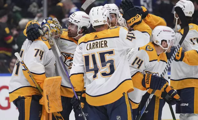 Nashville Predators goalie Juuse Saros (74) celebrates with Kiefer Sherwood (44) and the rest of the team after defeating the Vancouver Canucks in Game 5 of an NHL hockey Stanley Cup first-round playoff series, in Vancouver, British Columbia, on Tuesday, April 30, 2024. (Darryl Dyck/The Canadian Press via AP)