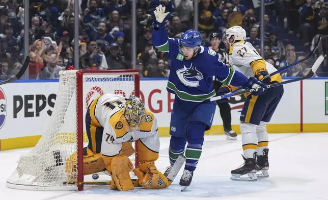 Vancouver Canucks' Pius Suter (24) celebrates a goal by Nikita Zadorov, not seen, against Nashville Predators goalie Juuse Saros (74) during the third period in Game 5 of an NHL hockey Stanley Cup first-round playoff series, in Vancouver, British Columbia, on Tuesday, April 30, 2024. (Darryl Dyck/The Canadian Press via AP)